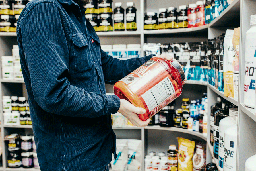 customer holding large tub of supplements