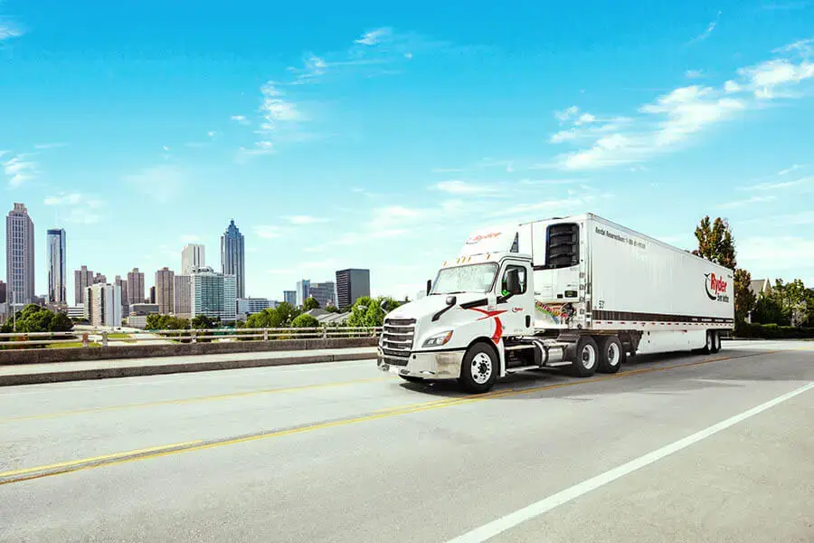 Ryder truck on highway in front of large city